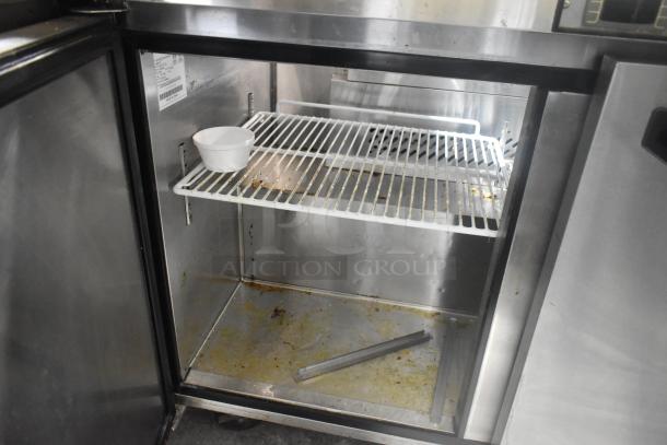 2020 Padela PDS-48-HC stainless steel commercial prep table interior. Features shelving and moderate wear.