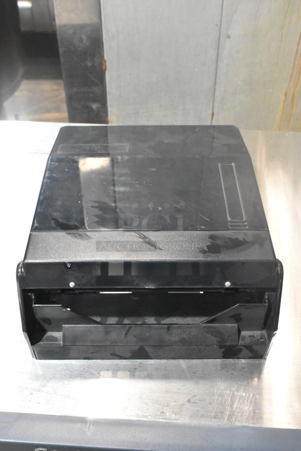Black poly wall mount paper towel dispenser, model TD-MFOLD, in fair condition with visible surface scratches.