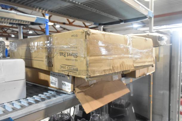 Cardboard box containing scratch and dent items, including Brand New Slate 14"x18" Trays and Bakers Lane Sheet Pans.