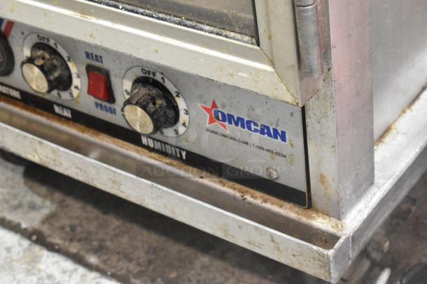 Omcan heated holding cabinet on casters, 115V, 1-phase, with temperature and humidity controls, showing signs of wear.