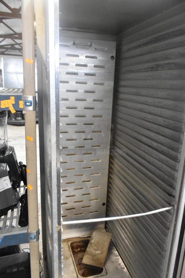 Omcan metal commercial heated holding cabinet on casters, shown open with shelves; powered at 115 volts, 1 phase.