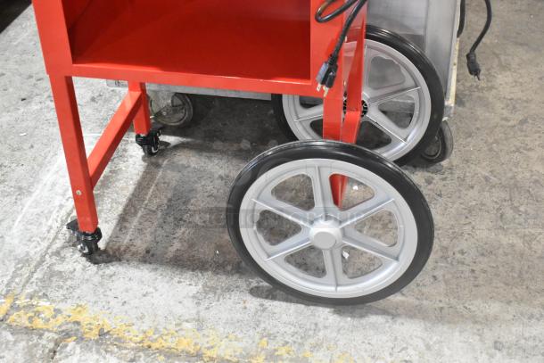 Carnival King 382PM30R Royalty Series 8 oz. red popcorn machine on stand, 120V, new with scratches, visible wheels and power cords.