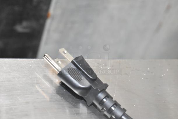 Close-up of a power plug for the AvaMix 928BL2K48 commercial blender, resting on a metallic surface.