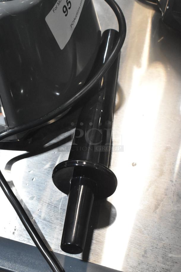 Black tamper accessory for AvaMix 928BL2E blender on metal surface. Scratch and dent condition visible.