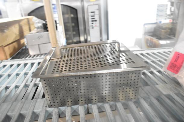Stainless steel straining bin, brand new, scratch and dent condition. Perforated design. Includes auction label "W001".