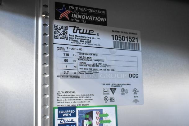 Label of True T-23F-HC freezer, showing model, voltage, compressor details, refrigerant type, and safety warnings. Made in the USA.