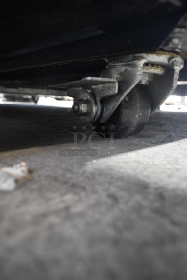 Close-up of a wheel caster on the base of the 2022 True TG2R-2S-HC commercial 2 door reach-in cooler.