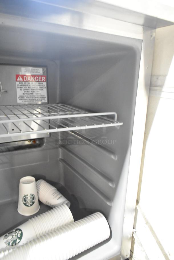 2020 Delfield stainless steel single door undercounter cooler, commercial casters, 115 volts, interior view with cups.