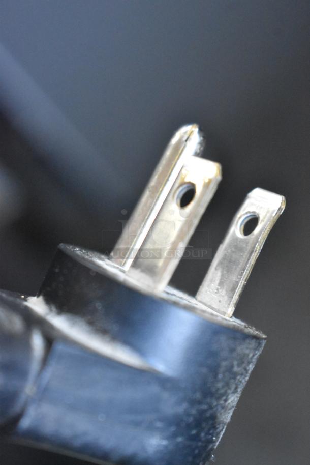 Close-up of a power plug for a Delfield 406P-STAR2 undercounter cooler. Black casing with metal prongs.