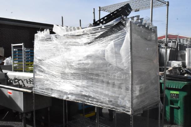 Chrome finish 3-tier shelving unit with contents, wrapped in plastic. Includes shelving poles. Buyer to dismantle; consider freight.