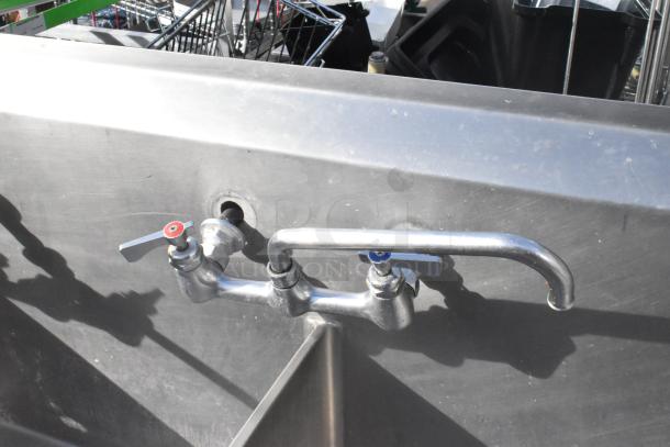 Stainless steel 3 bay sink with right side drain board, featuring 2 faucets and handles. Good condition.