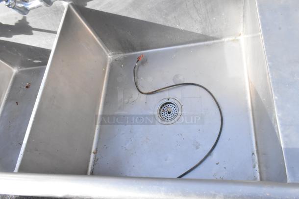 Stainless steel 3 bay sink with right side drain board, two faucets, handles. Good condition with minor wear.