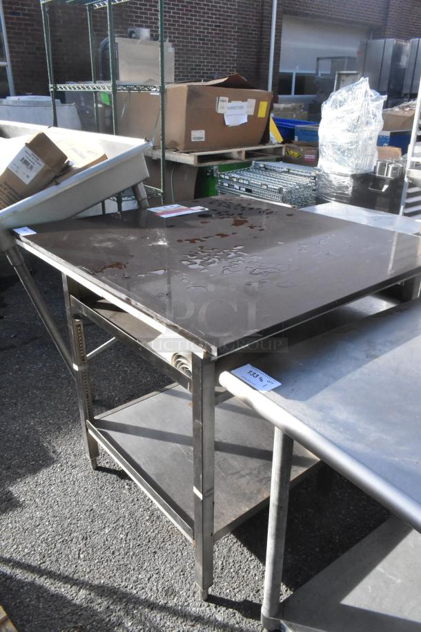 Industrial metal table with under shelf, used condition, visible surface wear and label tagged "133".