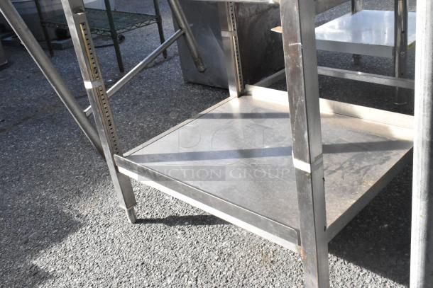 Metal table with under shelf, stainless steel, sturdy frame, adjustable height legs, good condition.