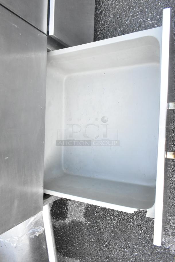 Stainless steel 4-drawer counter, showing open drawer with smooth interior. In good condition. Ideal for kitchen use.