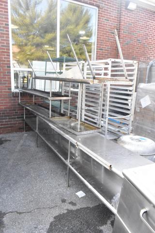 Three stainless steel over shelves, industrial design, on metal legs, in used condition, showing rust and wear.