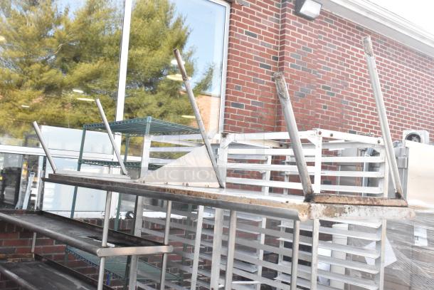 Three stainless steel over shelves, showing rust and wear, stacked outdoors. Ideal for maximizing storage space.