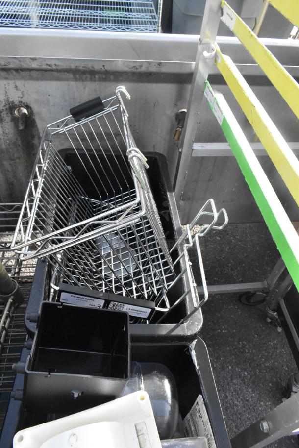 Pallet of various items including metal wire baskets, dish caddies, cup dispenser dolly, and metal rack. Good condition.