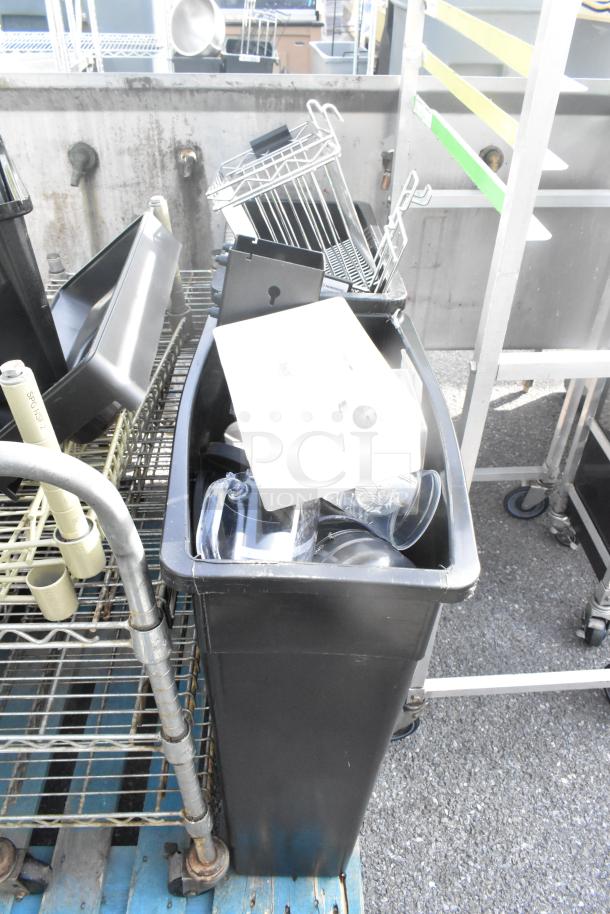 Pallet of various items including dish caddies, cup dispenser dolly, metal rack, assorted kitchen items; used condition.