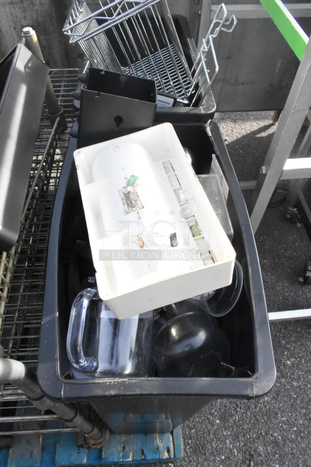 Pallet lot of various items including dish caddies, cup dispenser dolly, and metal rack. Items appear in used condition.