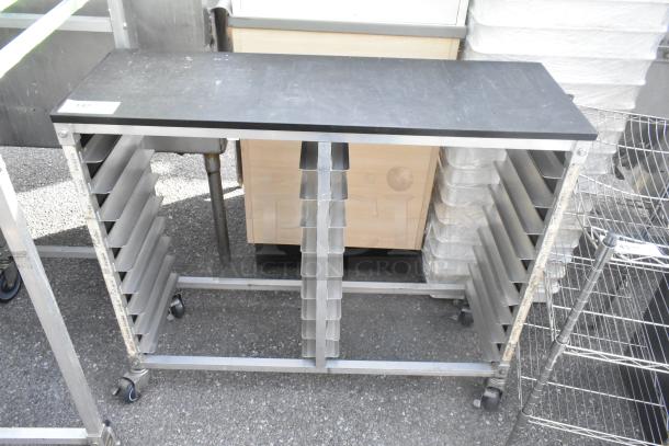 Metal commercial double pan transport rack with casters, multiple slots, sturdy condition, used for efficient kitchen transport.