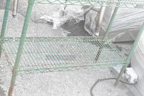 Green 4-tier wire shelving unit, aged condition, buyer must dismantle for shipping. Consider freight charges.