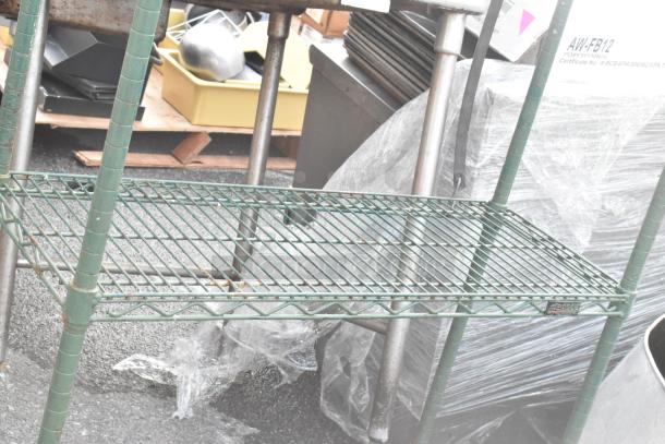 Green finish 4-tier wire shelving unit in used condition. Visible rust marks. Buyer must dismantle for shipping.
