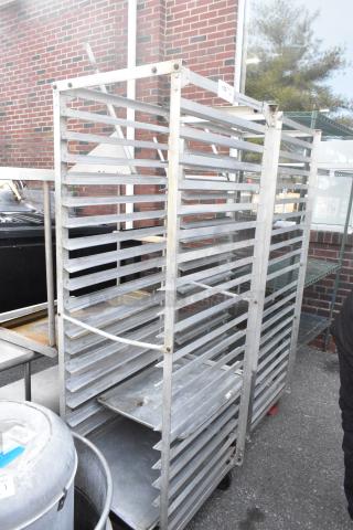 Two metal commercial pan transport racks on casters, outdoors. Solid construction; used condition. Auction label "152."