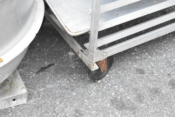 2 Metal commercial pan transport rack with visible casters. Rust observed on one caster. Suitable for bakery use.