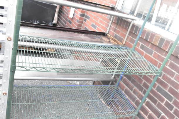 Green finish 4-tier wire shelving unit, showing some wear. Buyer must dismantle. Suitable for garage or storage use.