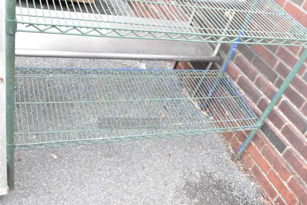Green 4-tier wire shelving unit, good condition, placed against brick wall. Buyer must dismantle for shipping.
