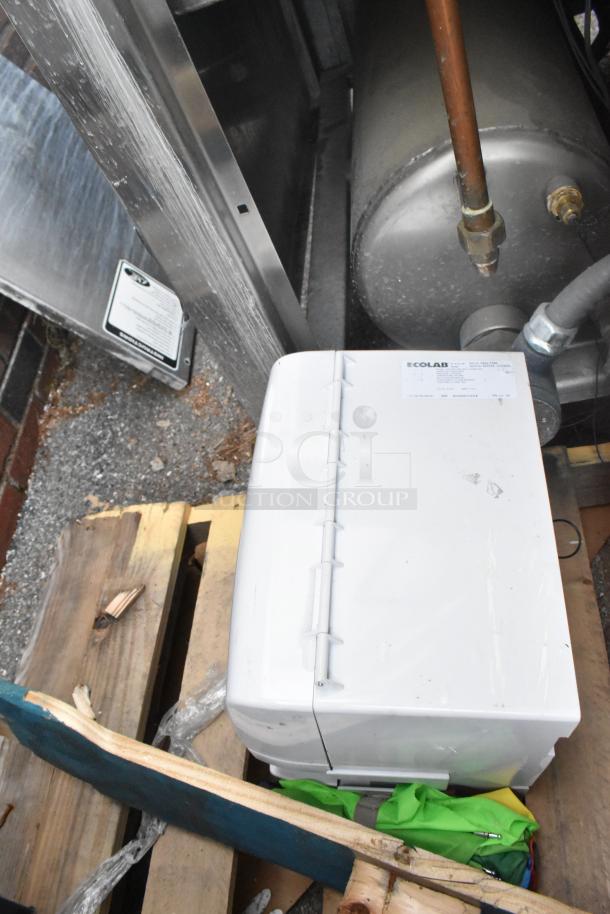 Brand new Ecolab HDCARE Conic Bag Dispenser on a pallet with minor dents, visible labeling on the front.