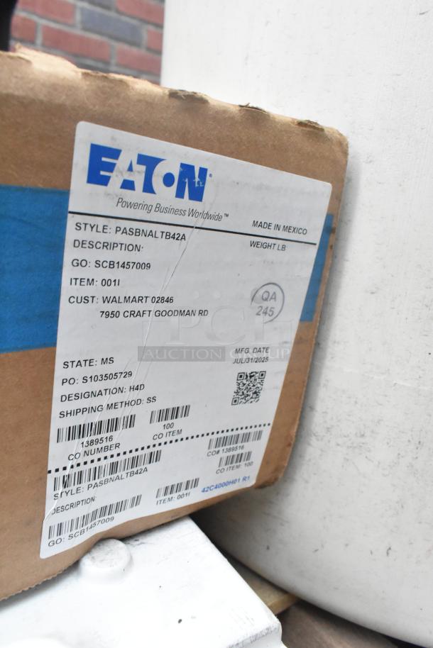 Brown shipping box with Eaton label, model SCB1457009, and details like manufacturing date and Walmart as the customer.