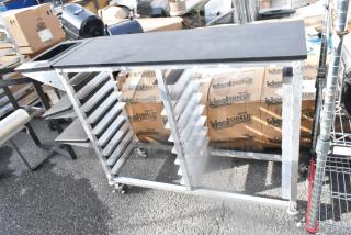 Metal double pan rack on commercial casters, featuring sturdy construction, multiple shelves for pans, and maneuverability.