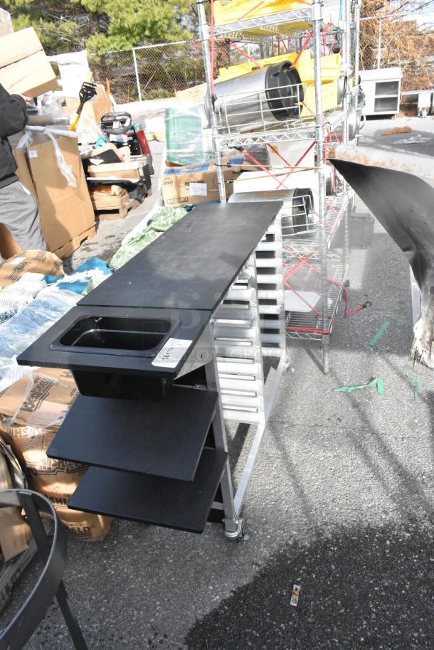 Metal double pan rack on commercial casters, featuring multiple shelves and a durable frame. Good condition, ideal for kitchen use.