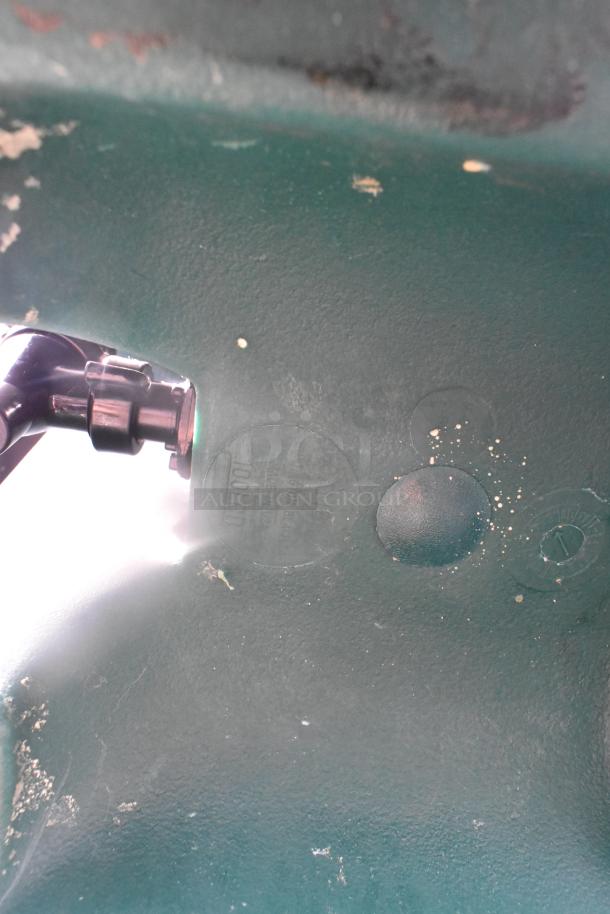 A green surface with rust spots and a metal component, possibly part of shelving hardware.