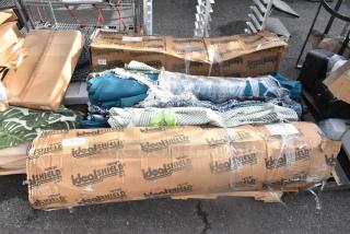 12 patio umbrellas in IdealShield boxes and mixed conditions, some fabric wraps. Auction lot with "12 Times Your Bid" labeling.