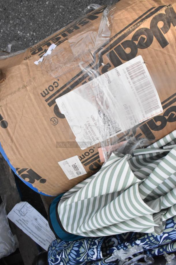 12 items including patio umbrellas; items display various patterns, in packaging; auction lot.