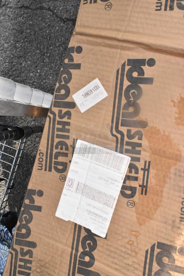 Cardboard box labeled "ideal Shield" with shipping labels, indicating a bundle of 12 patio umbrellas.