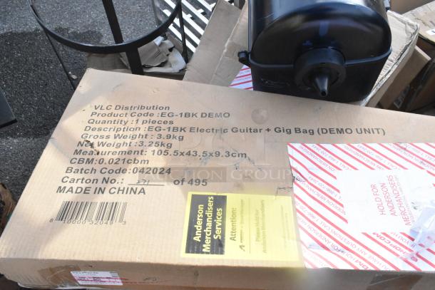 Cardboard box labeled for EG-1BK Electric Guitar with gig bag, indicating weight and dimensions. Includes Anderson Merchandisers label.