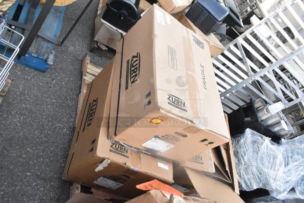 Three sealed boxes labeled "Zurn" containing Z5755-U white washdown urinals. Boxes are marked fragile, on a pallet.