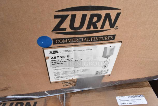 Cardboard box containing Zurn Z5755-U white washdown urinal, labeled "0.125-0.5 gpf," compliant with ASME standards.