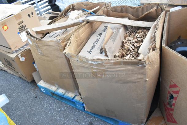 Damaged American Standard boxes on pallets, containing packing material. Visible markings and taped edges.