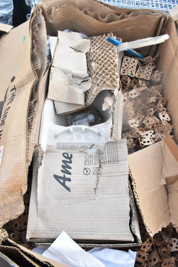 Damaged packaging of two American Standard items, partially visible in torn cardboard box, showing ceramics and packing materials.