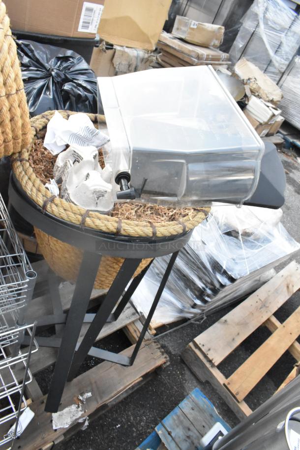 Pallet lot of items including a stand, wire baskets, basket, and poly bin. Mixed materials and assorted conditions.