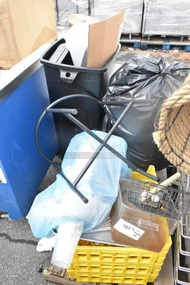 Pallet lot of assorted items including a black stand, wire baskets, yellow poly bin, and cardboard box. Mixed condition.