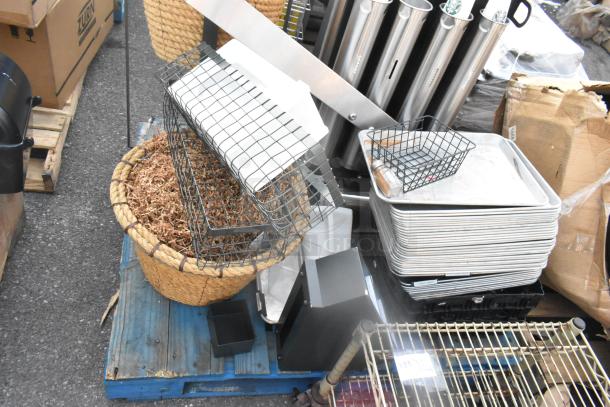 Pallet lot with basket, metal baking pans, and cup dispensers in used condition, includes various kitchen items.
