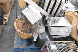 Pallet lot with basket, metal baking pans, and cup dispensers in used condition, includes various kitchen items.