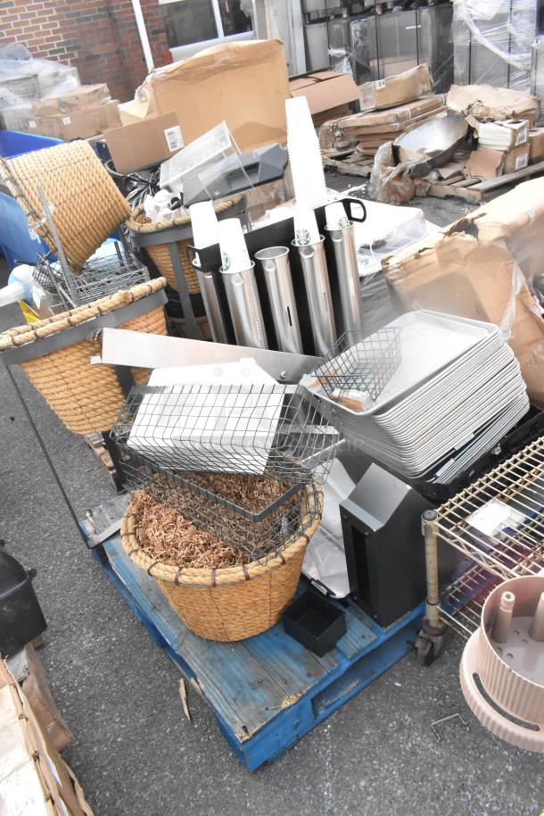 Pallet of assorted items including woven baskets, metal baking pans, and cup dispensers, in used condition.