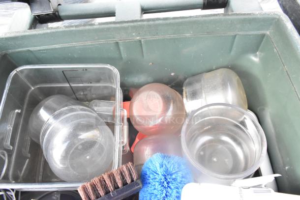 Green polymer trash can with clutter, includes containers, brush, and blue scrubber. Good condition, durable material.